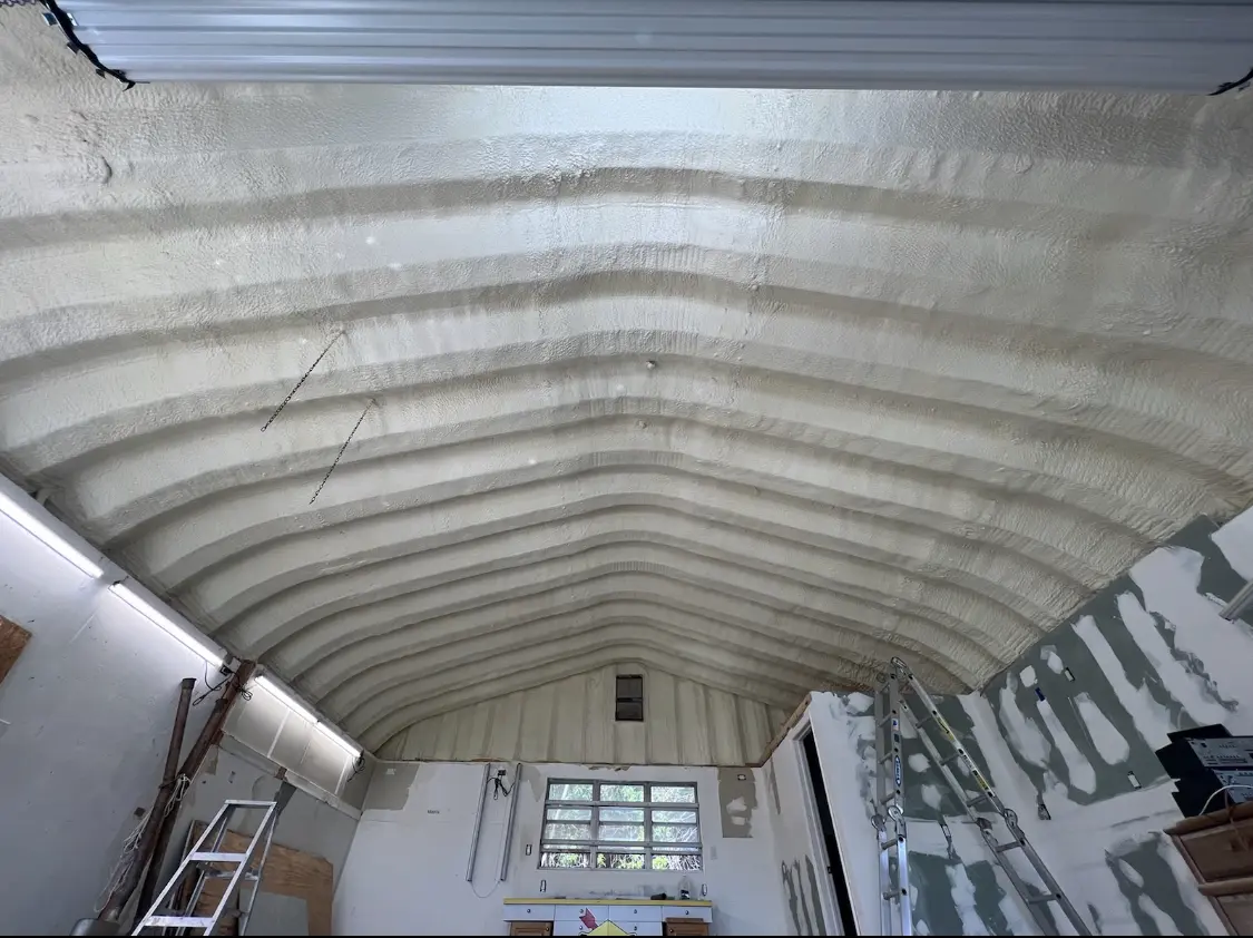 Spray polyurethane foam applied to the underside of a metal roof deck in Adams